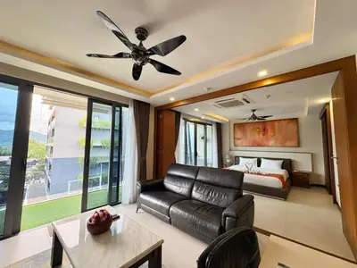 a living room with a couch and a bed and a ceiling fan at Large Luxurious 1-bedroom condos in Rawai in Rawai Beach