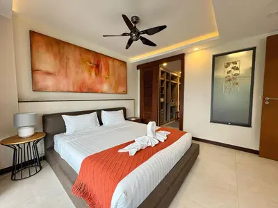 a bedroom with a bed with a ceiling fan at Large Luxurious 1-bedroom condos in Rawai in Rawai Beach