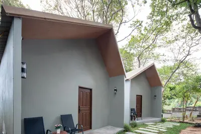 a small white house with a wooden door at Nature Vista Rawai in Nai Harn Beach