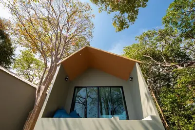 a house in the woods with a large window at Nature Vista Rawai in Nai Harn Beach