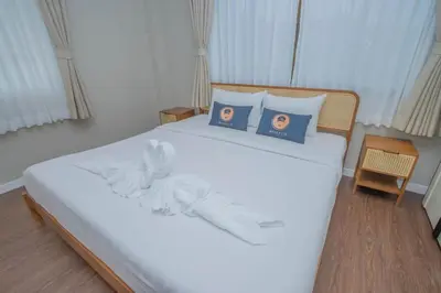 a bedroom with a white bed with two pillows at The Va Phuket Patong in Patong Beach