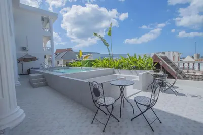 a patio with a pool and two chairs and a table at The Va Phuket Patong in Patong Beach