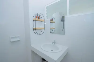 a white bathroom with a sink and a mirror at The Va Phuket Patong in Patong Beach