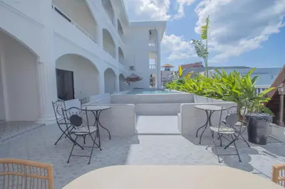 a patio with tables and chairs and a swimming pool at The Va Phuket Patong in Patong Beach
