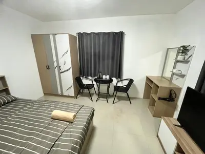 a bedroom with a bed and a table and chairs at 84 Bar & Guest House in Ban Huai Luk (1)