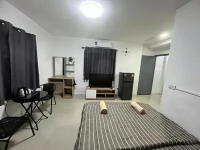 a room with a bed and a table and a television at 84 Bar & Guest House in Ban Huai Luk (1)