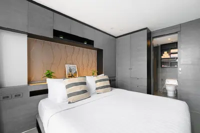 a bedroom with a large white bed with striped pillows at City Gate Kamala B607 by Phuket Sabay Rent in Kamala Beach