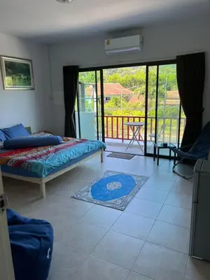 a bedroom with a bed and a balcony at Petunya Room 3 in Ban Huai Luk (1)