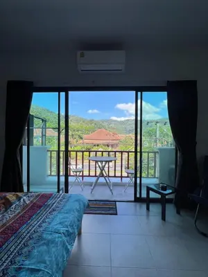 a bedroom with a bed and a balcony with a view at Petunya Room 3 in Ban Huai Luk (1)