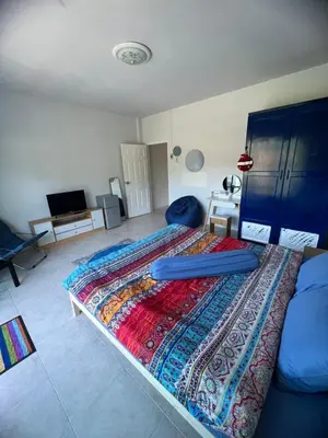 a bedroom with a bed with a colorful blanket on it at Petunya Room 3 in Ban Huai Luk (1)