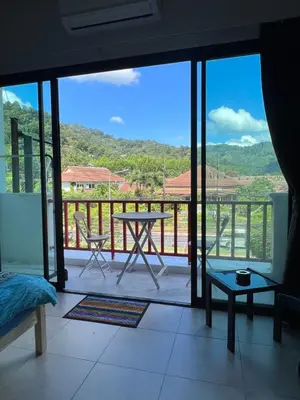 a room with a balcony with a table and a view at Petunya Room 3 in Ban Huai Luk (1)