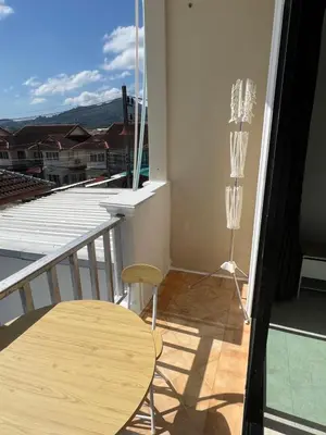 a balcony with a table and a view of a city at Petunya Room 4 in Ban Huai Luk (1)