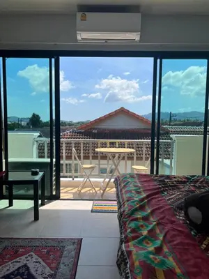 a bedroom with a view of a balcony at Petunya Room 4 in Ban Huai Luk (1)