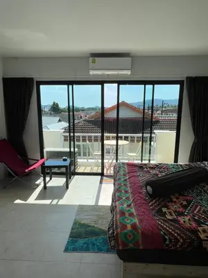 a bedroom with a bed and a balcony with a view at Petunya Room 4 in Ban Huai Luk (1)