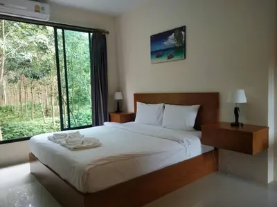 a bedroom with a large bed with a large window at Sj House Hotel Aonang in Ban Khlong Haeng