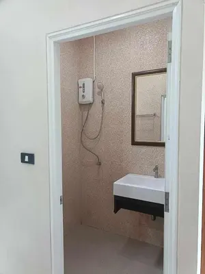 a bathroom with a sink and a mirror and a shower at Sj House Hotel Aonang in Ban Khlong Haeng