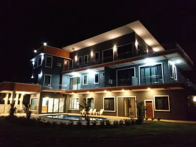 a large house with a pool in front of it at night at Sj House Hotel Aonang in Ban Khlong Haeng