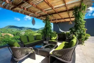 a patio with green furniture and a view of the mountains at Calypso rawai seaview apartment 600m walk to beach C4 in Phuket Town