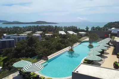 an overhead view of a large swimming pool with umbrellas at Calypso rawai seaview apartment 600m walk to beach C4 in Phuket Town