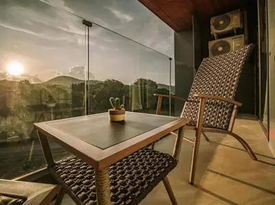 a table and a chair in a room with a window at Calypso rawai seaview apartment 600m walk to beach C4 in Phuket Town