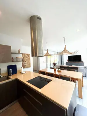 a kitchen with a counter top and a dining room at A spacious Balinese style villa with a large swimming pool on Rawai an electric motorcycle as a gift! in Ban Saiyuan (1)