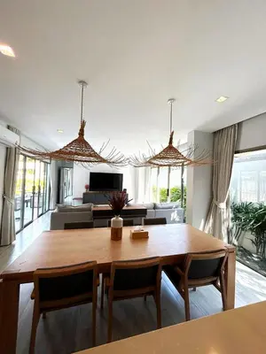 a living room with a wooden table and chairs at A spacious Balinese style villa with a large swimming pool on Rawai an electric motorcycle as a gift! in Ban Saiyuan (1)