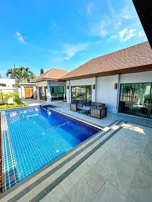 a swimming pool in front of a house at A spacious Balinese style villa with a large swimming pool on Rawai an electric motorcycle as a gift! in Ban Saiyuan (1)