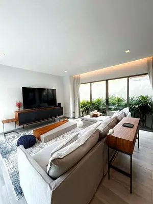 a living room with a large couch and a television at A spacious Balinese style villa with a large swimming pool on Rawai an electric motorcycle as a gift! in Ban Saiyuan (1)