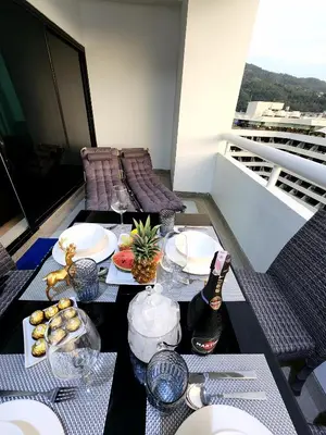 a table with plates of food on a balcony at 2 Bedroom apartments 1 min to sea in Patong Tower in Patong Beach