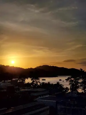 a sunset over a body of water with a mountain at 2 Bedroom apartments 1 min to sea in Patong Tower in Patong Beach