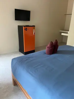 a bedroom with a blue bed and a television at Baanchomjan Kohyaoyai in Ban Nai Wat