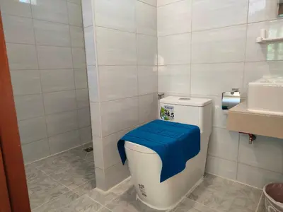 a bathroom with a toilet with a blue cover on it at Baanchomjan Kohyaoyai in Ban Nai Wat