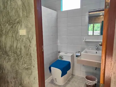 a bathroom with a toilet and a sink at Baanchomjan Kohyaoyai in Ban Nai Wat