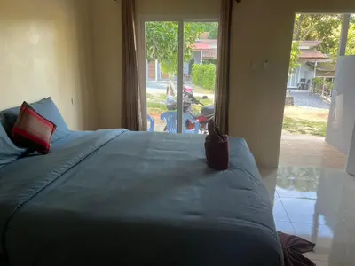 a bedroom with a large bed with a large window at Baanchomjan Kohyaoyai in Ban Nai Wat