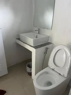 a bathroom with a white toilet and a sink at Baanchomjan Kohyaoyai in Ban Nai Wat