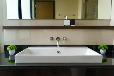 a white sink in a bathroom with two potted plants at Friendly Townhouse Laguna Park in Thalang