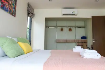 a bedroom with a bed with towels on it at Friendly Townhouse Laguna Park in Thalang
