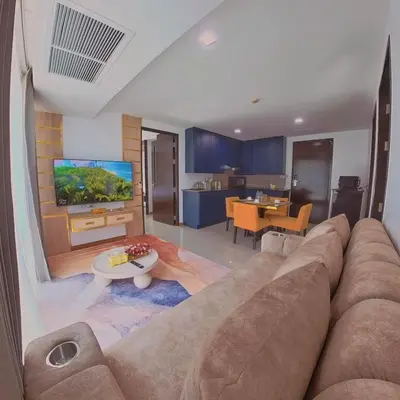 a living room with a large couch and a tv at The Kris 2 Bedrooms 2 Bathrooms Apartment in Patong Beach