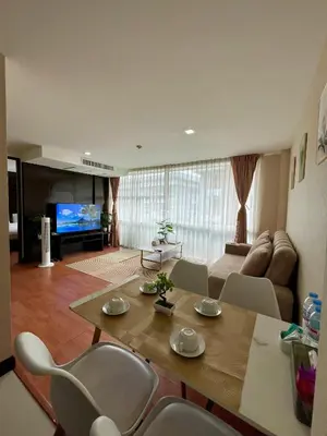 a living room with a table and chairs and a couch at The Kris 2 Bedrooms 2 Bathrooms Apartment in Patong Beach