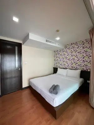 a bedroom with a bed with two shoes on it at The Kris 2 Bedrooms 2 Bathrooms Apartment in Patong Beach