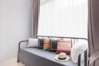 a bed with colorful pillows and a hat on it at Reach Patong beach in one minute in Patong Beach