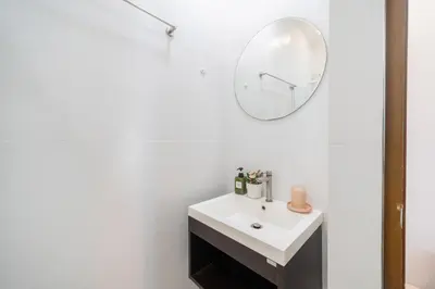 a white bathroom with a sink and a mirror at Reach Patong beach in one minute in Patong Beach