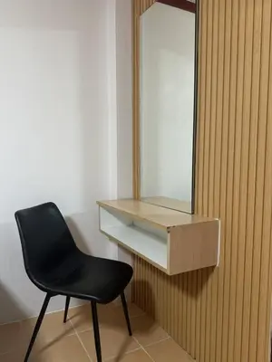 a black chair sitting in front of a mirror at Priew Wan Guesthouse in Patong Beach