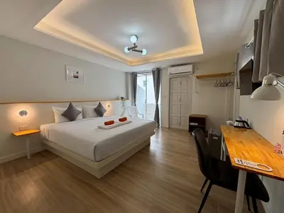 a hotel room with a bed and a table and a desk at Priew Wan Guesthouse in Patong Beach