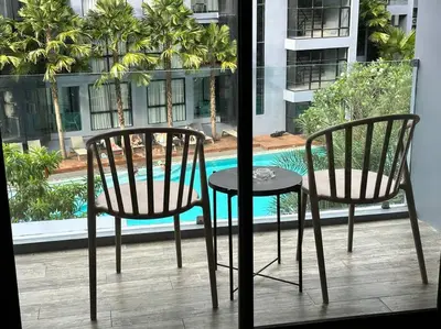 two chairs and a table in front of a window at Kamala Beach P33 Pool view 2 Bedroom Suite in Kamala Beach