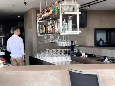 a man standing behind a bar in a restaurant at Kamala Beach P33 Pool view 2 Bedroom Suite in Kamala Beach