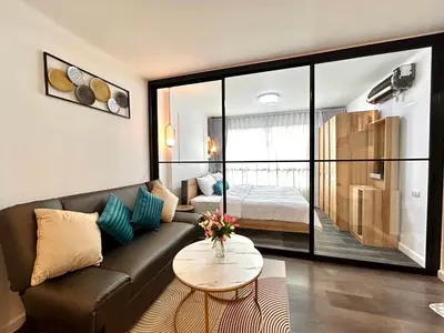 a living room with a couch and a bed at Vibe Old Town 452 in Phuket Town