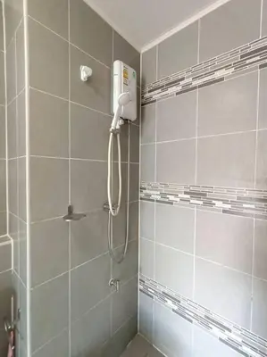 a bathroom with a shower with a phone on the wall at Vibe Old Town 452 in Phuket Town