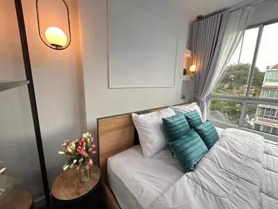 a bedroom with a white bed with a window at Vibe Old Town 452 in Phuket Town