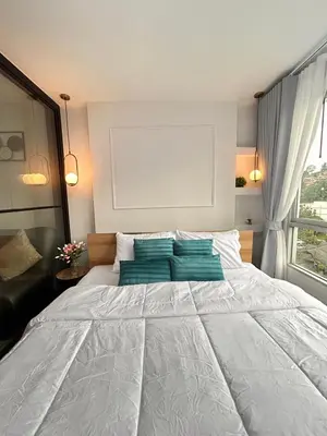 a bedroom with a large white bed with green pillows at Vibe Old Town 452 in Phuket Town